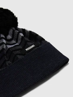Cappello in lana vergine zig zag con logo e pon pon